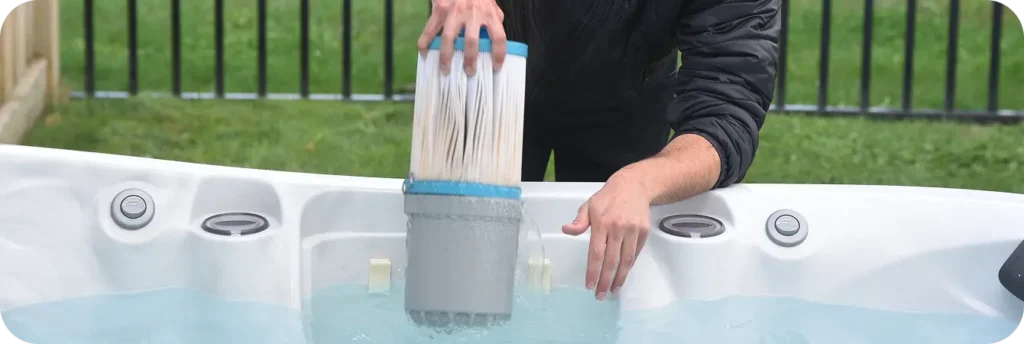 Technician lifting a hot tub filter cartridge during a service appointment.