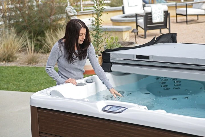 woman checking her hot tub water during hot tub maintenance